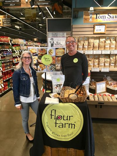 Teri Delany and Dave DuPree work a sample table for their Flour Farm gluten-free flour recently at My Fresh Basket in Spokane. (Photo courtesy of Flour Farm)