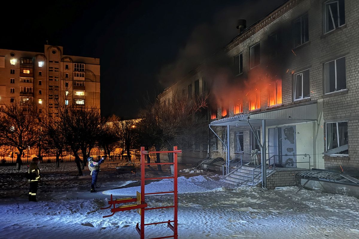 Emergency employees work at the site of a school hit during a Russian missile strike on Sunday in Kharkiv, Ukraine. (Reuters)