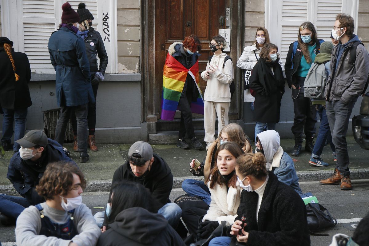 Students stage a sit-in outside the Fenelon High School in Lille, northern France, Friday, Dec. 18, 2020. About 100 teenagers rallied in northern France to pay homage to a transgender student who killed herself this week after facing tensions with school officials around her gender identity.  (Michel Spingler)