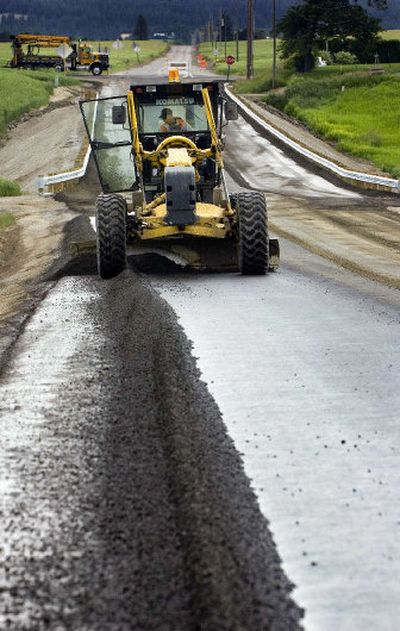 Bret Cupp, of N.A. Degerstrom Inc., uses a grader to move asphalt to the shoulder of Peone Road between Market Street and Bruce Road last week.
(Holly Pickett / The Spokesman-Review)