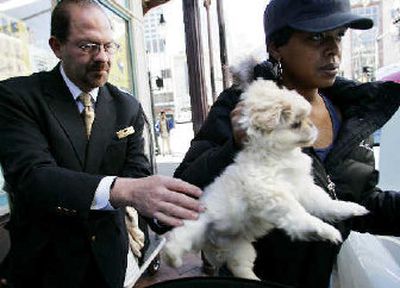 
Hotel employee Gerardo Flores helps a woman move out of the Astor Crowne Plaza on Canal Street in New Orleans on Monday. 
 (Associated Press / The Spokesman-Review)