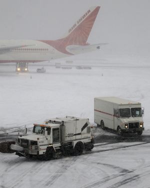 An Air India plane is seen at Newark Liberty International Airport on Sunday during a snowstorm that caused thousands of flights to be canceled in the Northeast.  (Associated Press)