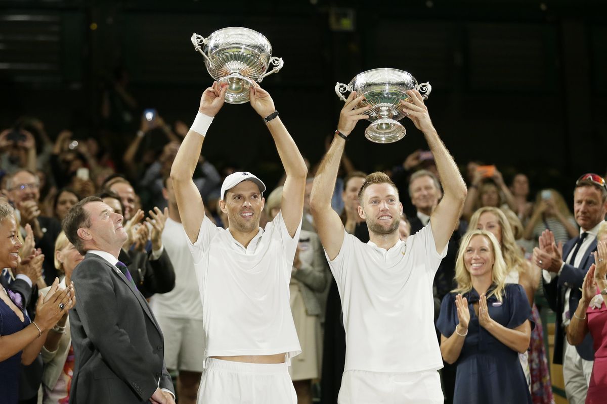 Mike Bryan, left, and Jack Sock of the US hold up their trophies after defeating South Africa’s Raven Klaasen and New Zealand’s Michael Venus in the men’s doubles final match at the Wimbledon Tennis Championships, in London, Saturday July 14, 2018. (Tim Ireland / Associated Press)