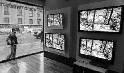 
A passerby watches the big screen HDTVs as he window-shops outside the Tweeter electronics store on Boylston Street in Boston. Sunday's Super Bowl showdown between the Chicago Bears and Indianapolis Colts is amplifying a high-definition TV buying frenzy that already was under way thanks to a 20 percent to 30 percent drop in prices from a year ago and heavy promotions by retailers and manufacturers. 
 (Associated Press / The Spokesman-Review)