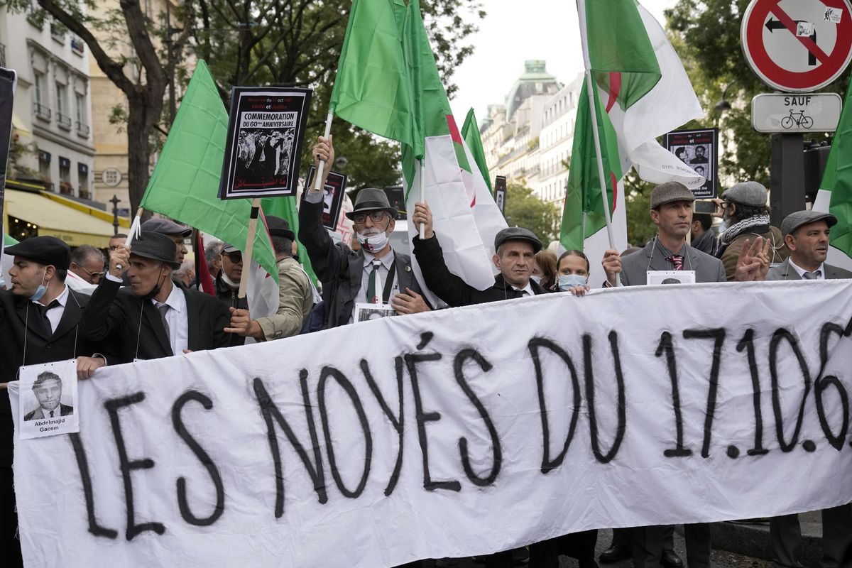 Demonstrators hold a banner reading: The drowned of 17.10.61 in Paris, Sunday, Oct. 17, 2021. A tribute march was organized for the 60th anniversary of the bloody police crackdown on a protest by Algerians in the French capital, during the final year of their country