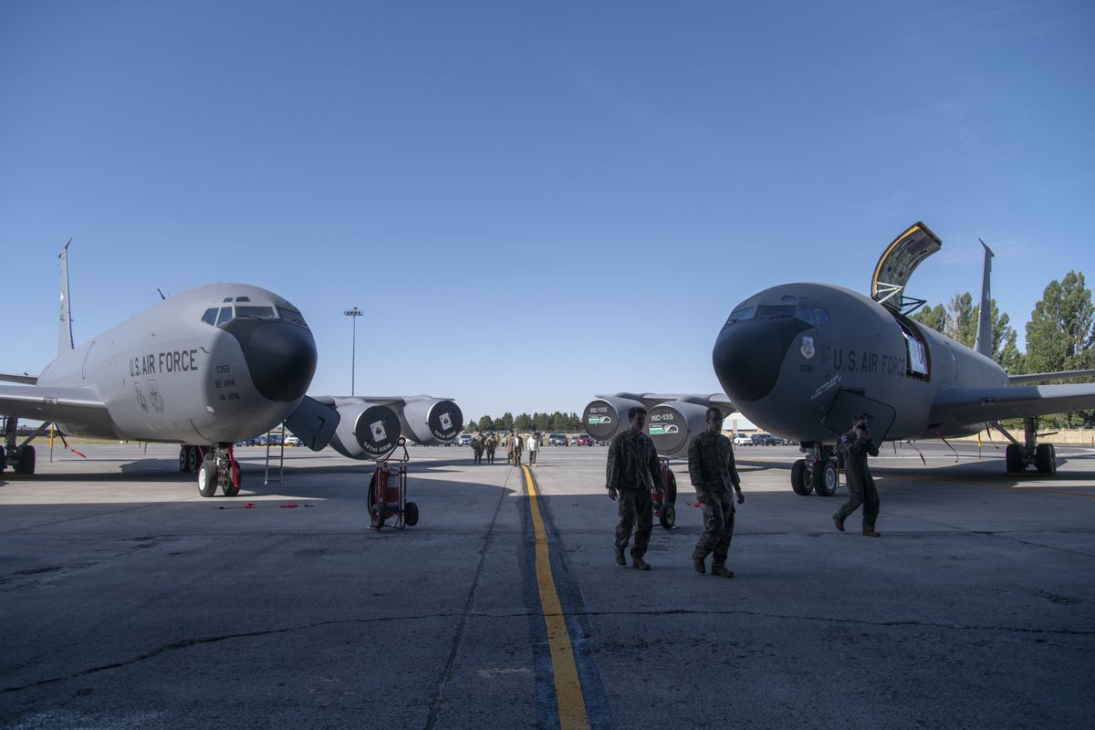 Air Force personnel and guests walk between two KC-135 tanker aircraft arranged as a backdrop to the change of command ceremony at Fairchild Air Force Base on Monday, July 25, 2022. Outgoing commander, Col. Cassius Bentley, turned his command over to Col. Chesley Dycus.  (Jesse Tinsley/The Spokesman-Review)