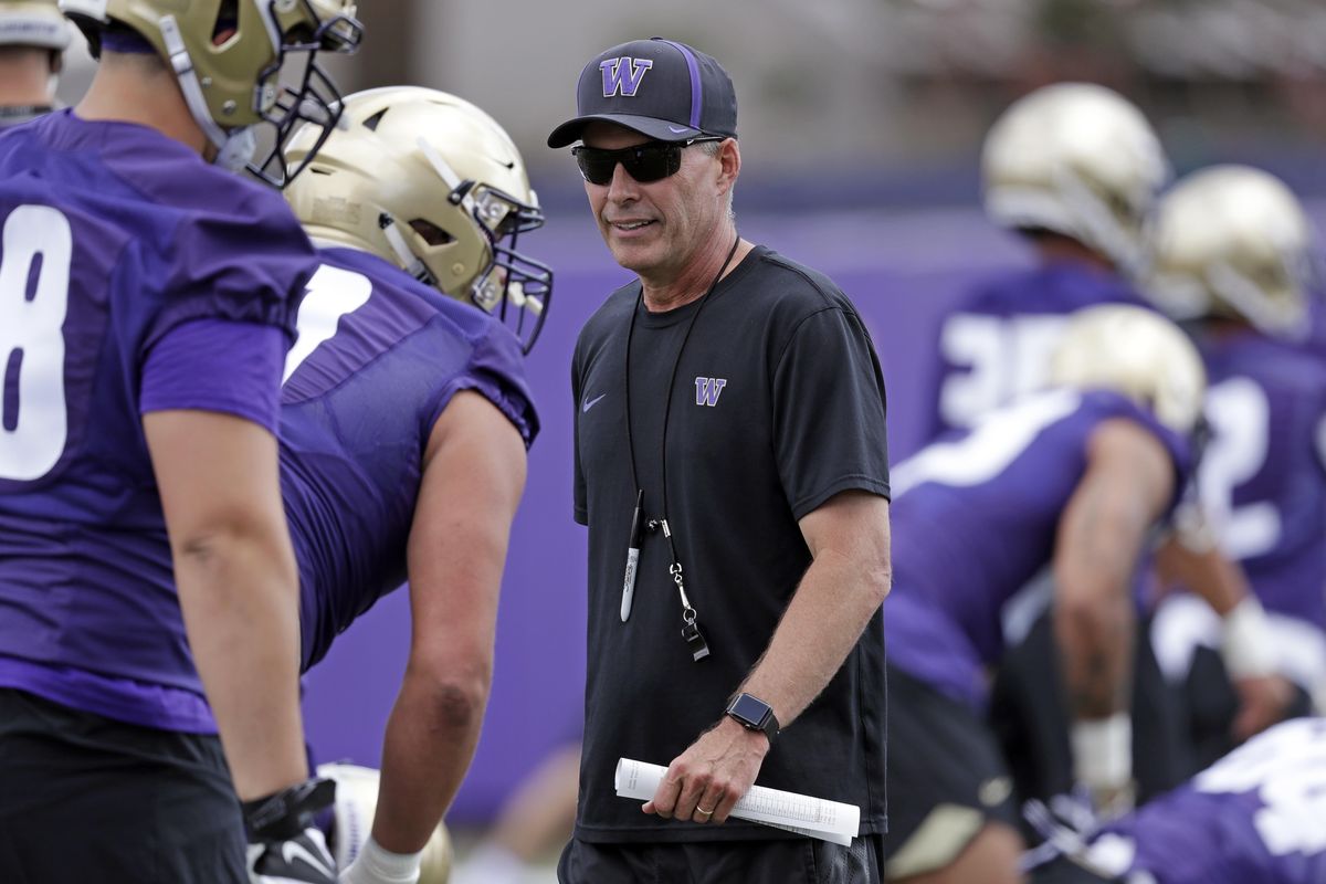 This Aug. 3 photo shows Washington coach Chris Petersen walking on the field during a team football practice in Seattle. Petersen’s Huskies are the preseason favorites to win the Pac-12 with their roster full of NFL-caliber talent, but the entire league is looking for an improved season after going 1-8 in bowl games last winter. (Elaine Thompson / AP)