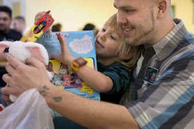 
At Airway Heights Corrections Center, inmate Jeff White shows his daughter, Alyza White, 4, all the toys Santa gave her at the 
