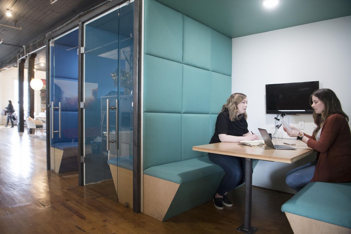 At Fellow Coworking in the Washington Cracker Co. building, graphic artist Millie Schnebly, left, talks with Fellow Coworking community manager Amanda Dixon in one of the many spaces that renters can use in the cavernous space. (Jesse Tinsley / The Spokesman-Review)