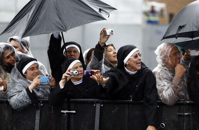 Nuns wave at and takes pictures of Pope Francis as he drives by in his popemobile as he leaves Aparecida, Brazil, Wednesday, July 24, 2013. Tens of thousands of faithful flocked to the tiny town of Aparecida, tucked into an agricultural region halfway between Rio de Janeiro and Sao Paulo, where he is celebrated the first public Mass of his trip in a massive basilica dedicated to the nation's patron saint. (Victor Caivano / Associated Press)