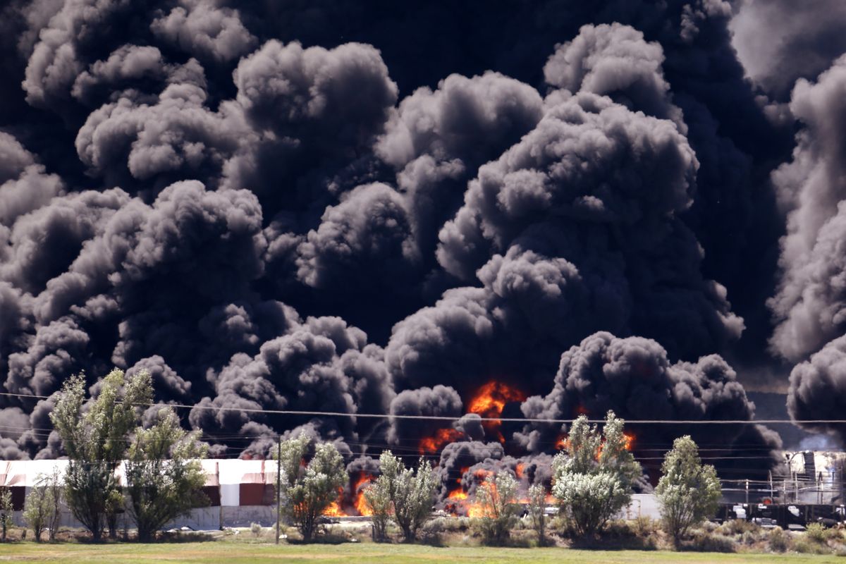 Smoke and flames rise above a fire burning several buildings at the Inland Tarp & Liner company Friday, July 17, 2015, in Moses Lake, Wash. Grant County Sheriff