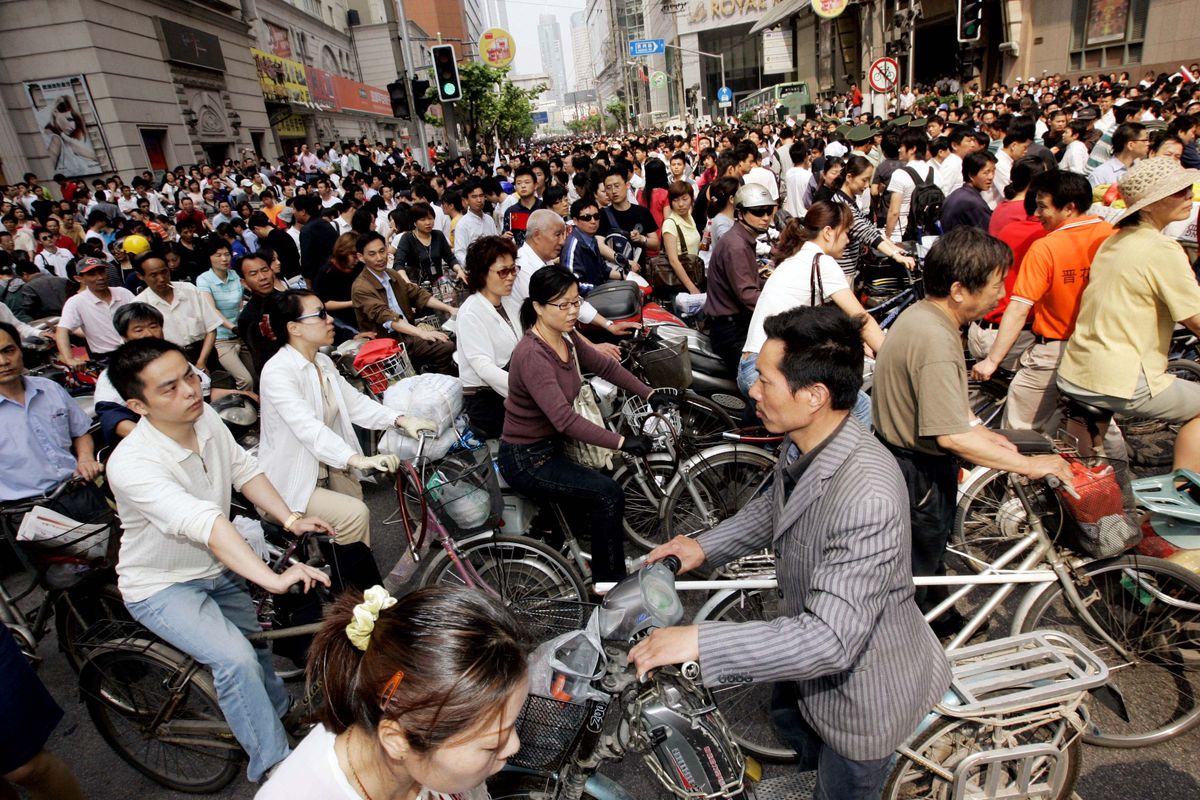 Commuters on bicycles, electric bikes and mo-peds make their way across a street last month  in Shanghai, China.  (Associated Press / The Spokesman-Review)