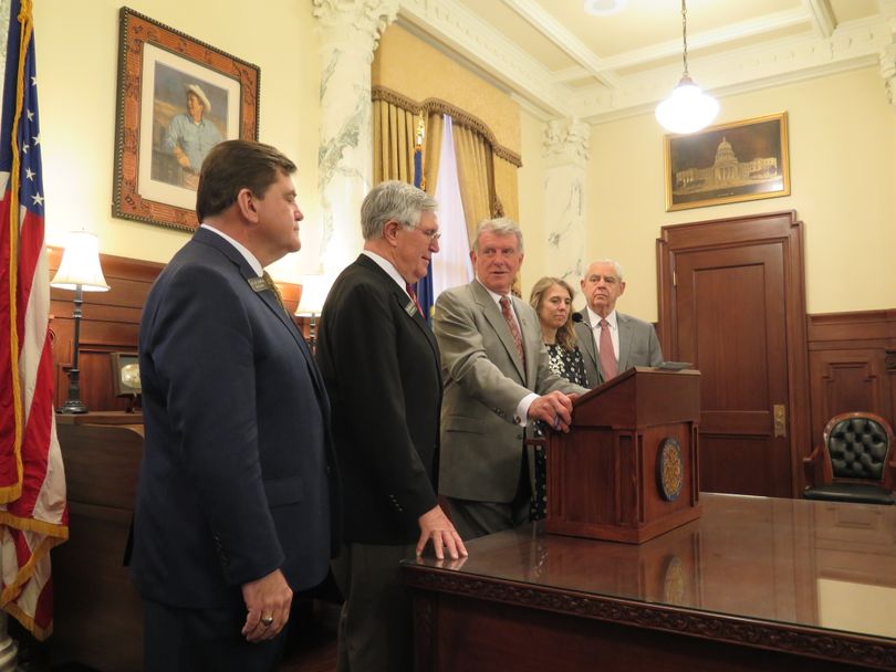 Gov. Butch Otter congratulates Rep. Lance Clow, second from left, at a ceremonial signing of HB 578, Clow's internet sales tax bill, on Friday morning, March 22, 2018. (The Spokesman-Review / Betsy Z. Russell)