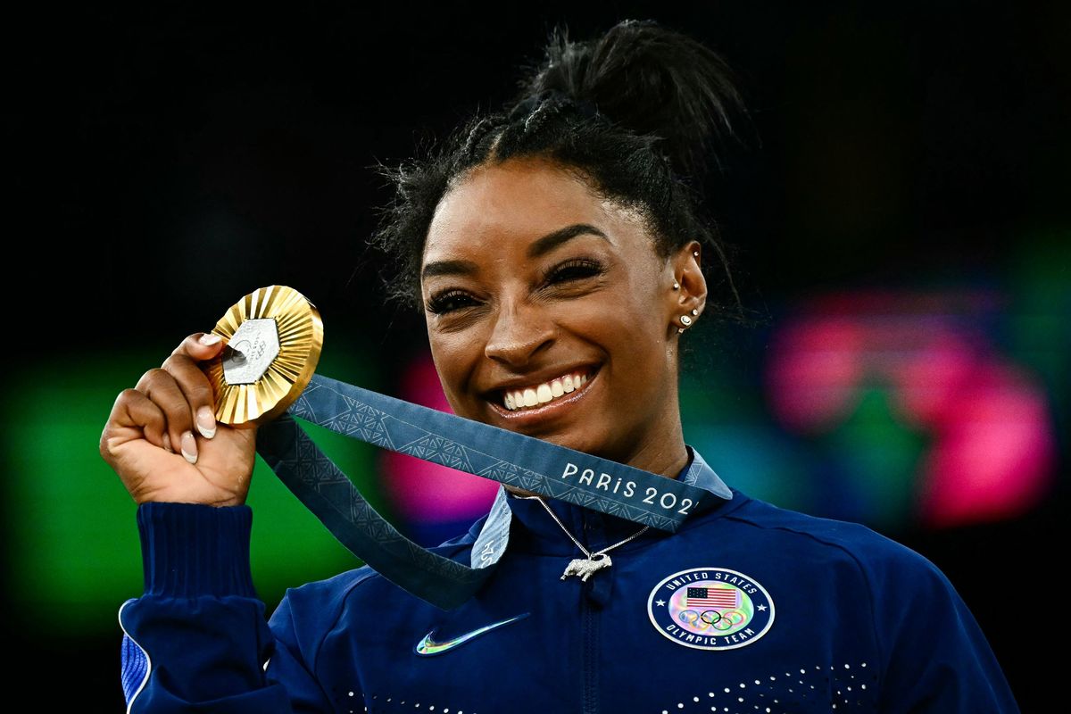 Simone Biles poses with her gold medal during the podium ceremony after the artistic gymnastics women’s all-around final during the Paris Games at the Bercy Arena on Thursday.  (Loic Venance/AFP/Getty Images North America/TNS)