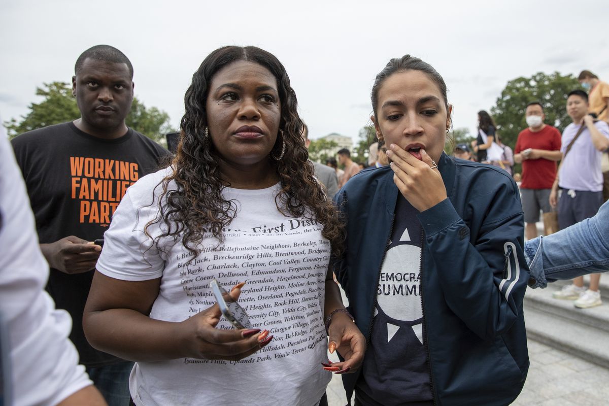 In this Aug. 3, 2021, photo, Rep. Cori Bush, D-Mo., and Rep. Alexandria Ocasio-Cortez, D-N.Y., react to the announcement that the Biden administration will enact a targeted nationwide eviction moratorium outside of Capitol Hill in Washington. The rare clash this week between the Biden administration and congressional Democrats over a lapsed eviction moratorium could become a blueprint for even larger fights that lie ahead.  (Amanda Andrade-Rhoades)