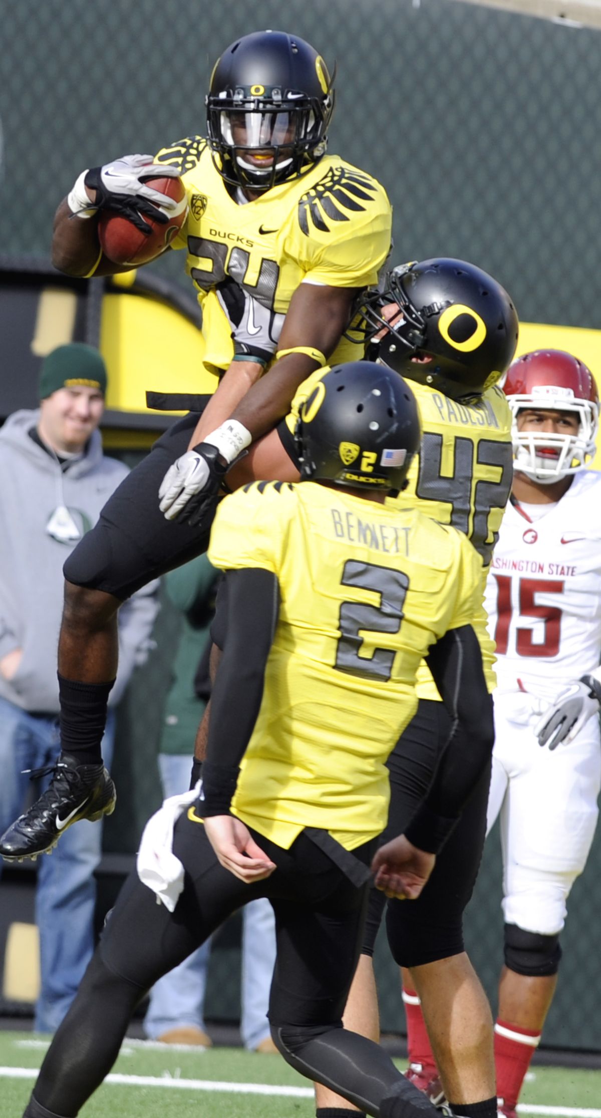 Oregon’s Kenjon Barner, background, celebrates his second-half TD with Bryan Bennett (2) and David Paulson. (Associated Press)