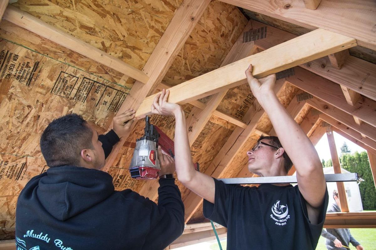Spokane Valley High School students Ethan Steiner, left, and Michael Alkana use a nail gun on framing for a door on a playhouse for the Vanessa Behan Crisis Nursey on May 16, 2017. (Dan Pelle / The Spokesman-Review)