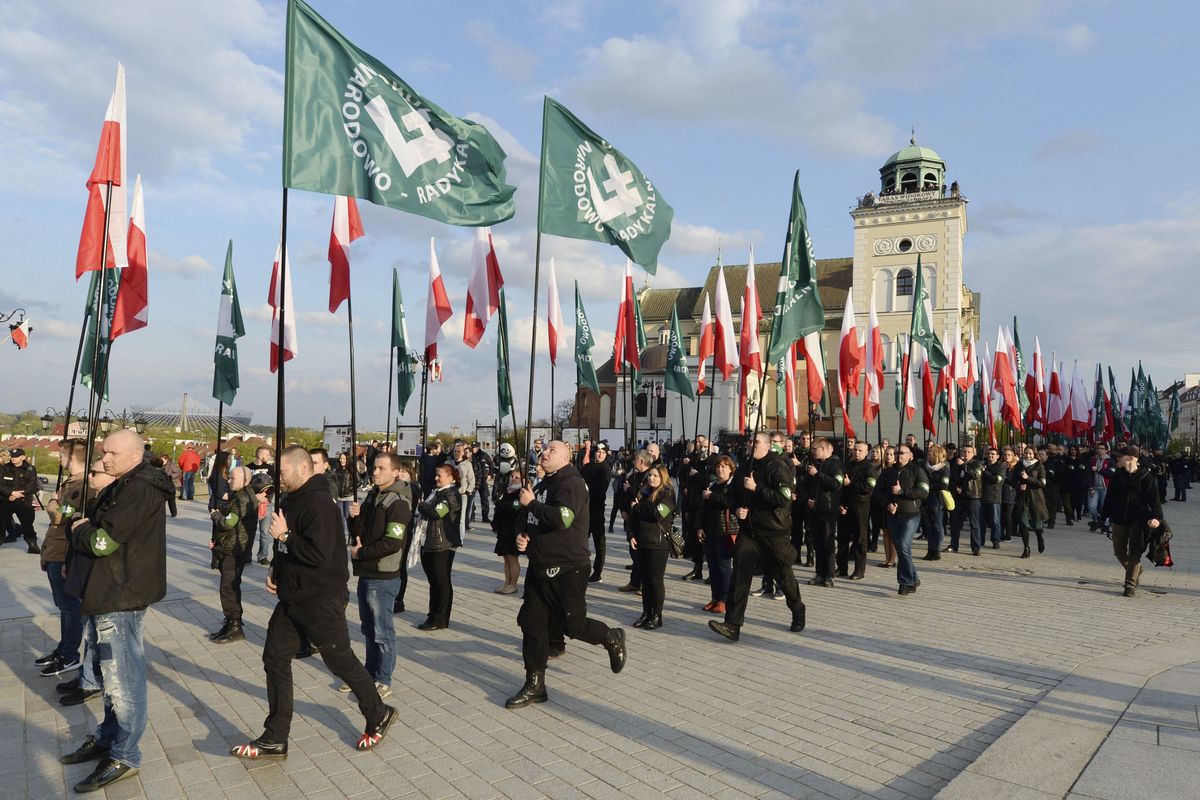 FILE - This April 29, 2017 file photo shows members of a right-wing extremist group, the National Radical Camp, marching in Warsaw, Poland. A scandal has erupted in Poland over the appointment of a historian to a state historical body who in his youth took part in demonstrations with the group and was photographed years ago doing a right-armed fascist salute. The historian, Tomasz Greniuch, has apologized for the mistake, calling it 