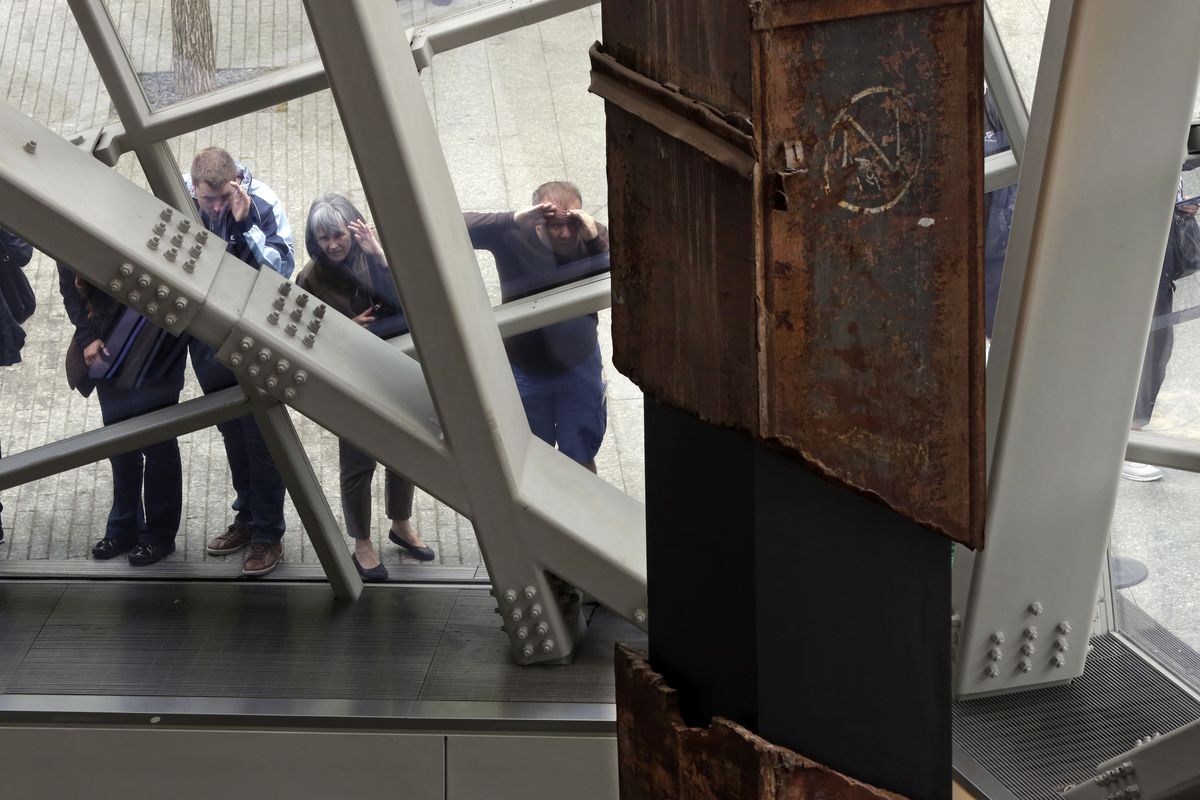 Visitors to the September 11 Memorial & Museum peek through a window at World Trade Center tridents on Wednesday. The museum opens next week. (Associated Press)