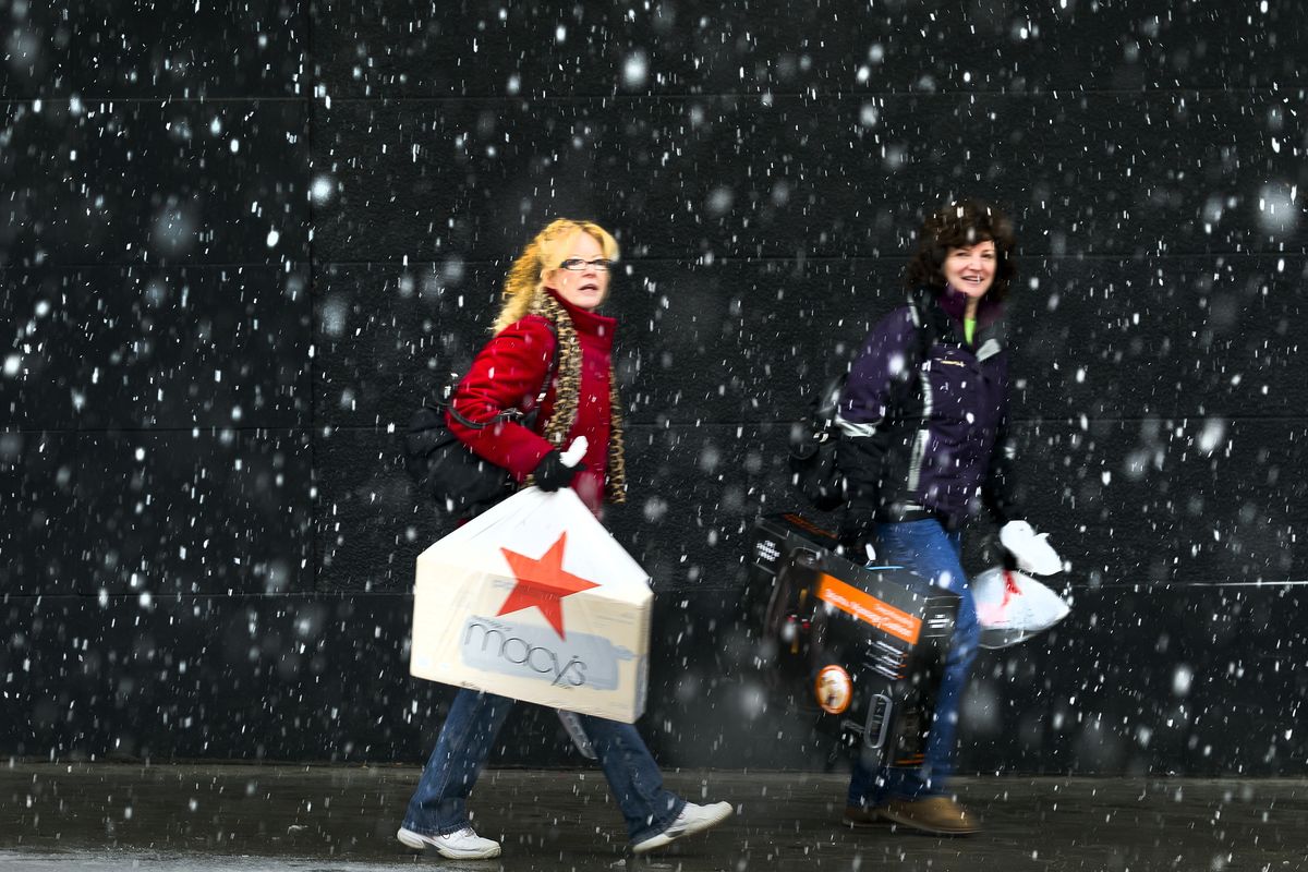 Above: Marsha Murphy, left, and Joan Durkoop make their way through large snowflakes after shopping the Black Friday sales at the downtown  Macy’s department store on Friday.  (Colin Mulvany)