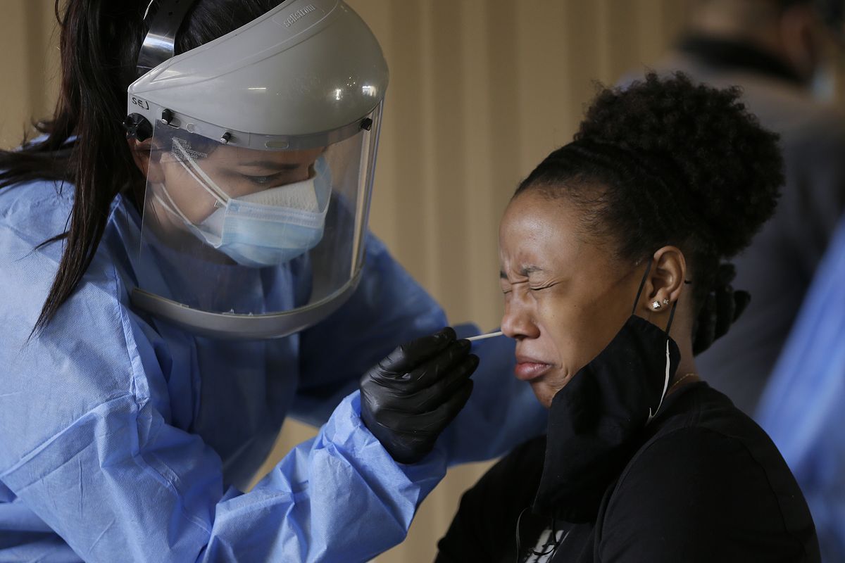 Sasha Jacquez tests The University of Texas at El Paso student Ariona Gill for coronavirus Friday, Oct. 16, 2020, at the UTEP Fox Fine Arts Center in El Paso, Texas. Deaths per day from the coronavirus in the U.S. are on the rise again, just as health experts had feared, and cases are climbing in nearly every single state. In El Paso, authorities instructed people to stay home for two weeks and imposed a 10-p.m.-to-5-a.m. curfew because of a surge that has overwhelmed hospitals. (Mark Lambie)