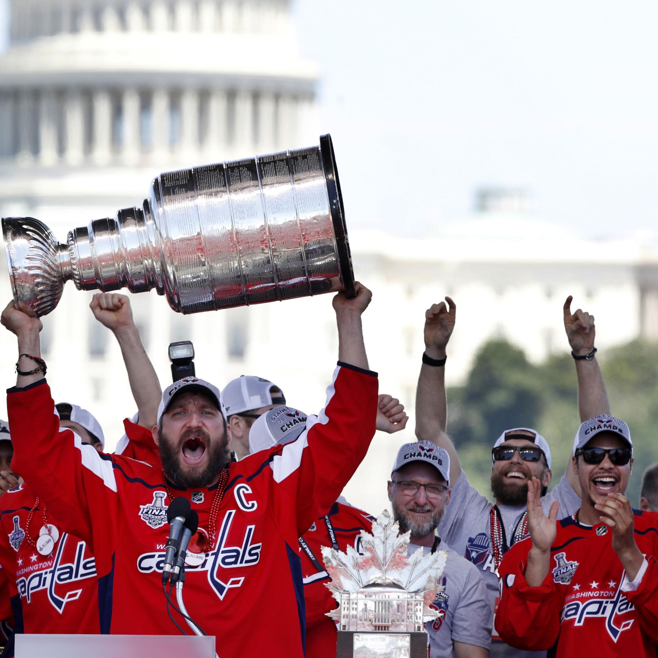 A fan carries a home-made Stanley Cup made of mostly empty beer cans as  people begin to arrive for the Washington Capitals Stanley Cup victory  parade on Constitution Ave., along the National