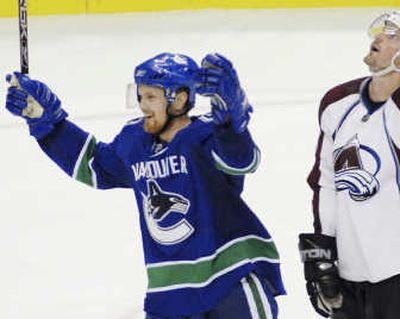 
Associated PressCanucks' Henrik Sedin, left, celebrates his game-winning goal.
 (Associated Press / The Spokesman-Review)