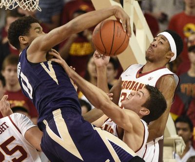 Washington forward Marquese Chriss, left, reaches for a rebound in front of Southern California guard Elijah Stewart, right, and Nikola Jovanovic, bottom during the second half of an NCAA college basketball game in Los Angeles, Saturday, Jan. 30, 2016. Southern California won 98-88. (Kelvin Kuo / Associated Press)