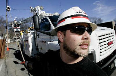 
Verizon Utility worker Brian Roop, pulls a cable as he and co-worker Steve Hammond, in bucket, install fiberoptic cable in Richmond, Va. Verizon is spending billions to build a massive network bringing video as well as broadband internet and phone services to homes. 
 (Associated Press / The Spokesman-Review)