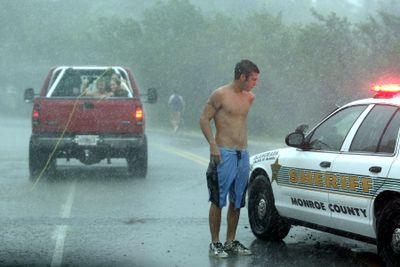 Monroe County Sheriff stops Kyle Holloran, 20, from being towed behind a truck while riding a board in Islamorada, Fla., during Tropical Storm Fay on Monday. (Associated Press / The Spokesman-Review)