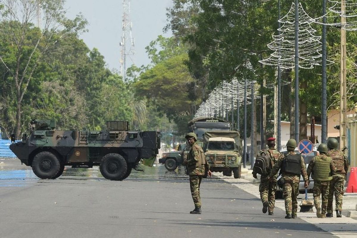 Soldiers patrol in front of the headquarters of Benin