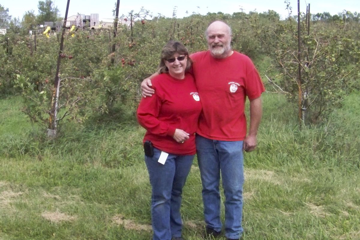  Cindy and Frank Femling, owners of Afton Apple Orchard, near Hastings, Minn., stand among their apple trees in August 2009. The Femlings  and other growers are suing the University of Minnesota over a licensing deal for the hot new SweeTango apple.  (Associated Press)