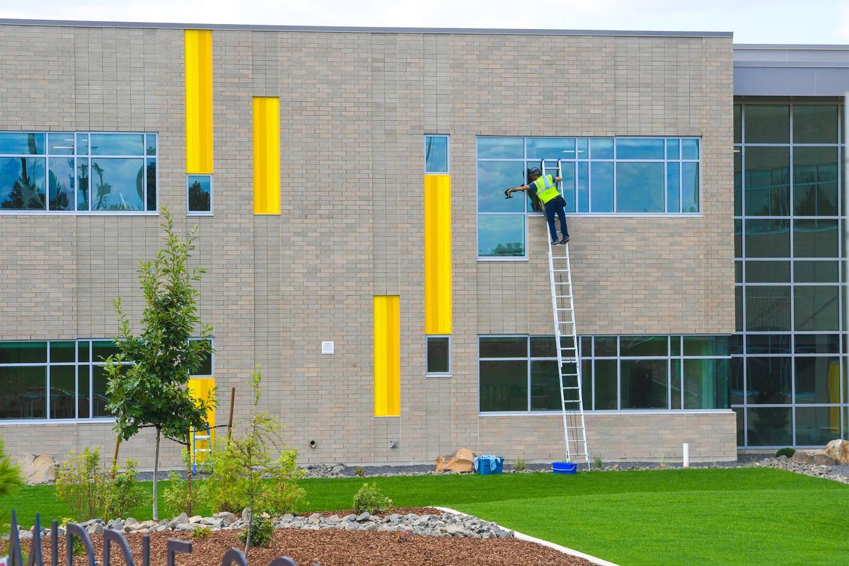 Tony Schloss, of Squeaky Clean, washes the exterior windows on the east-side of the new Glover Middle School, Monday, Aug. 23, 2021 in Spokane.  (DAN PELLE/THE SPOKESMAN-REVIEW)