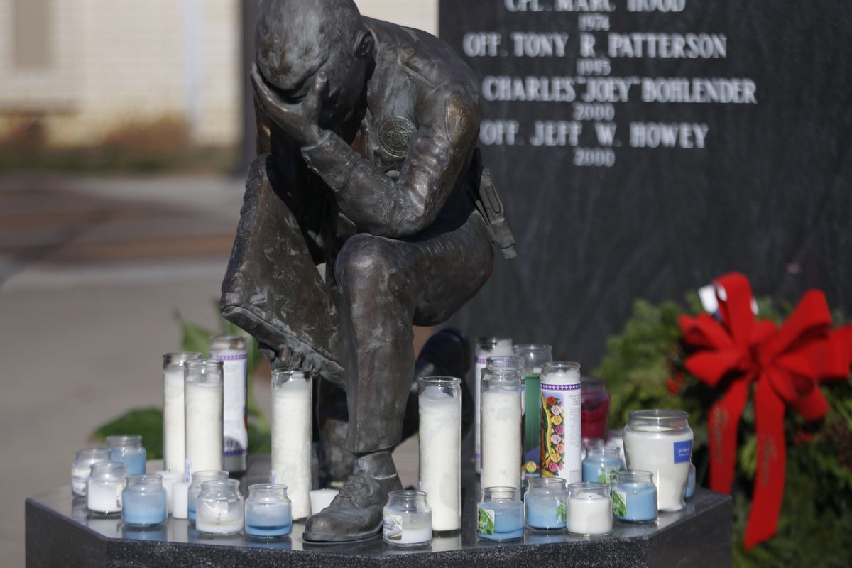 Candles accumulate for fallen officers who were fatally shot as they investigated a suspicious vehicle, at a police memorial outside the law enforcement center in Topeka, Kan., Monday, Dec. 17, 2012. A suspect in the killings is dead after a nearly two-hour armed standoff, authorities said Monday. (Orlin Wagner / Associated Press)