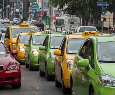Los Angeles-area taxi drivers circle City Hall in their cabs Tuesday to protest unregulated ride-share services being promoted through smartphone applications and social media. (Associated Press)