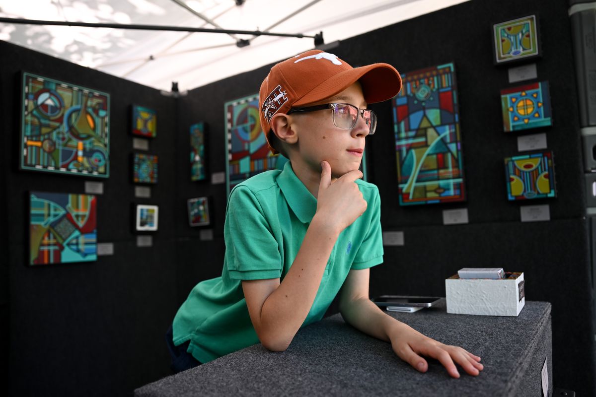 Eli Driver, 10, awaits customers as he mans the sales counter for his father, Denny Driver, of Denny Driver Studios, during the MAC’s ArtFest 2025 on Friday on the MAC Campus.  (Tyler Tjomsland/The Spokesman-Review)