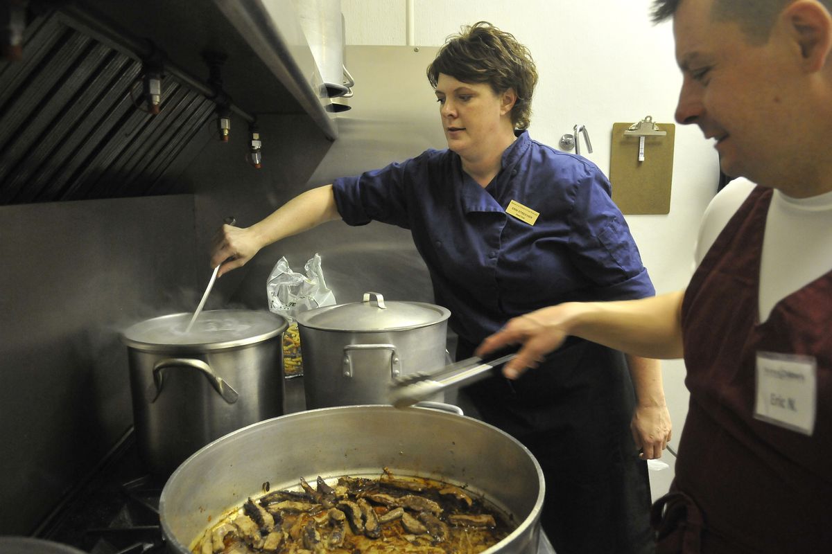 Chef Erin Streicher, left, stirs pasta as volunteer cook Eric Nelson, right, browns beefs at the Women and Children’s Free Restaurant in the basement of Christ of Hope Open Bible Church on North Monroe Street on Aug. 21. Streicher overseas the kitchen which makes meals from donated food items. (Jesse Tinsley)