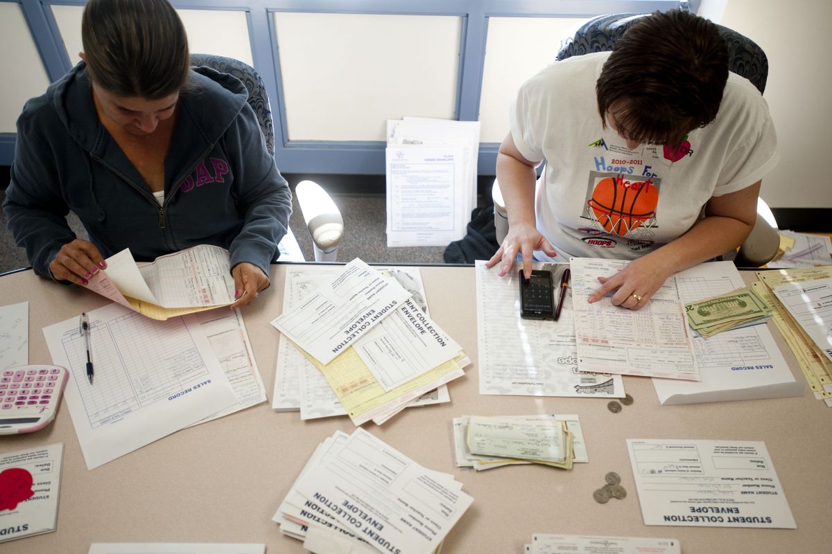 Paula Wiemer, left, a volunteer with the PTA, and PTA President Stephanie Hayden, sort through money and forms on Wednesday at East Farms STEAM Magnet School. (Tyler Tjomsland)