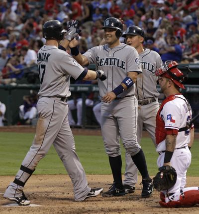 Justin Smoak, left, hit two three-run homers against Texas. (Associated Press)