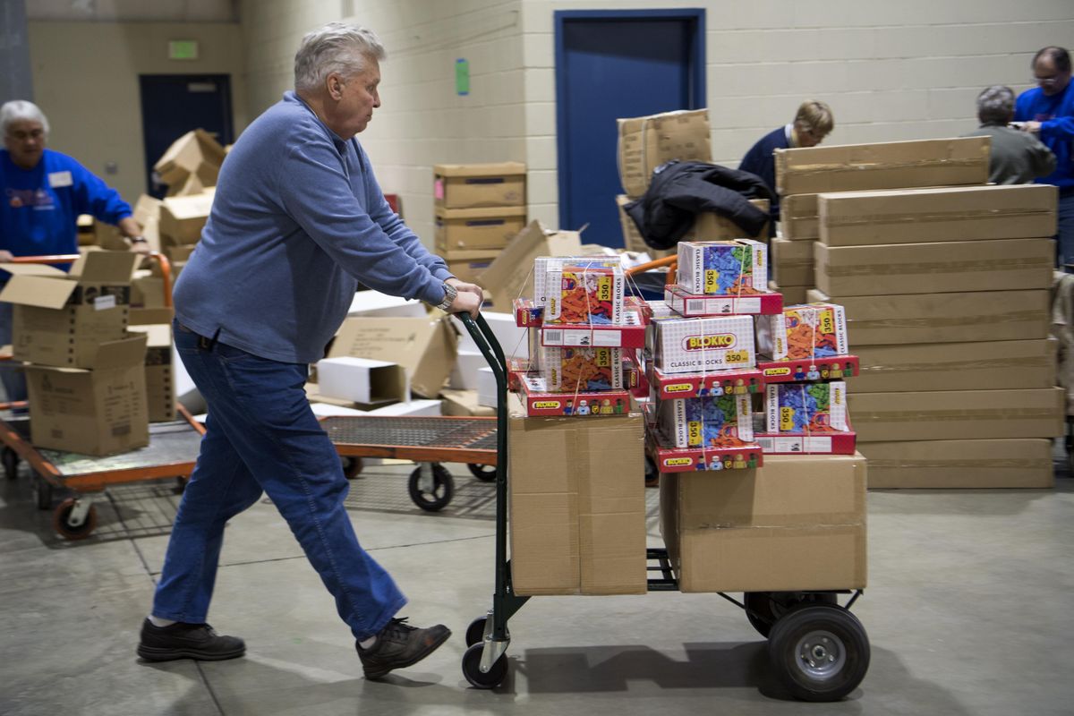 Longtime Christmas Bureau volunteer Randy Olson moves toys to the toy room at the venerable Christmas charity  Dec. 7, 2017, at the Spokane County Fairgrounds. (Jesse Tinsley / The Spokesman-Review)