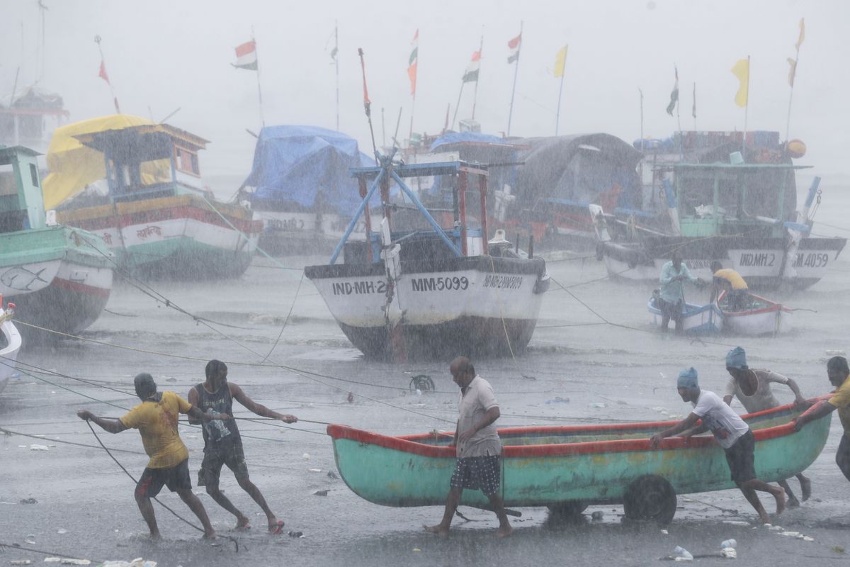 Fishermen try to move a fishing boat to higher ground on the Arabian Sea coast Monday in Mumbai, India, as Cyclone Tauktae approached.  (Rafiq Maqbool)