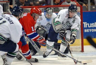 
Spokane's Chris Bruton battles Seattle's Bud Holloway, left, and Benn Olson for control in front of goalie Jacob DeSerres.
 (Jesse Tinsley / The Spokesman-Review)
