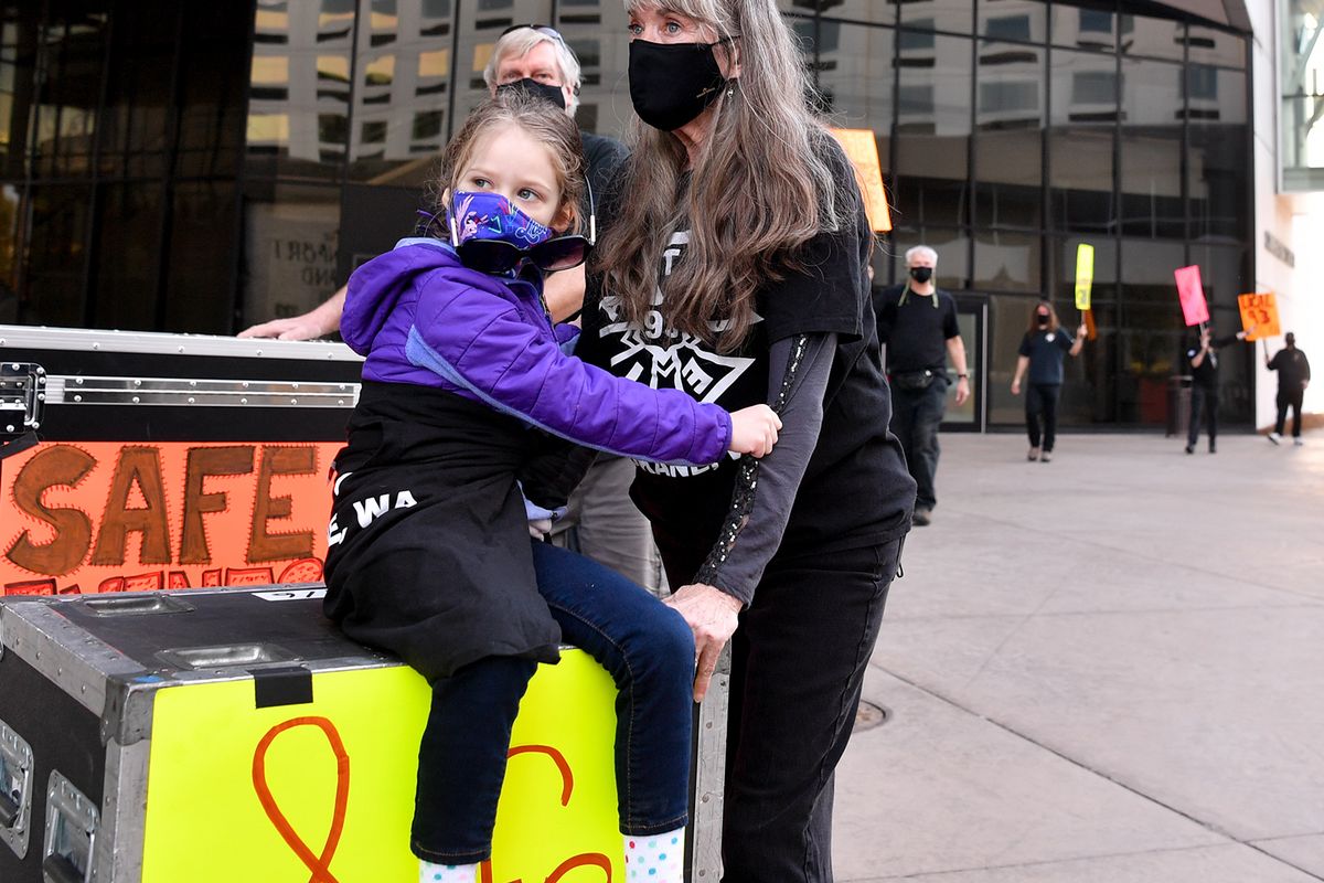 Leslie Lathrop pushes granddaughter Rori Shanahan atop a flight case with fellow stagehands and supporters during a rally marking the one-year anniversary of the COVID-19 shutdown.  (Tyler Tjomsland/THE SPOKESMAN-REVIEW)