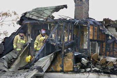 
Investigators comb through a triplex at Post and Knox in north Spokane on Tuesday morning. A fire Monday night caused extensive damage to the building. 
 (Christopher Anderson/ / The Spokesman-Review)