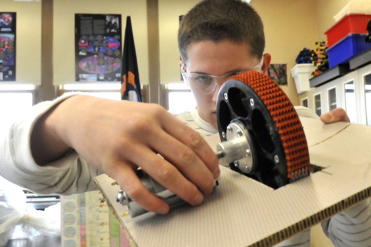 Sam Hatfield, a junior at Lewis and Clark High School, mounts a motor on a board Monday, April 2, 2012, in an LC classroom.  The motor is part of a test platform that will replicate the robotics team