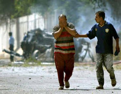 
Iraqis react at the scene of a car bombing that killed Izzedin Saleem, president of the Iraqi Governing Council, at a checkpoint just outside the 