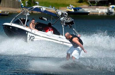 
Nick Murto passes the tow rope behind his back and spins as his wife, Jody, watches from the boat on Liberty Lake. Murto runs Wakefirst.com, a social networking site for wakeboard enthusiasts. 
 (Joe Barrentine / The Spokesman-Review)