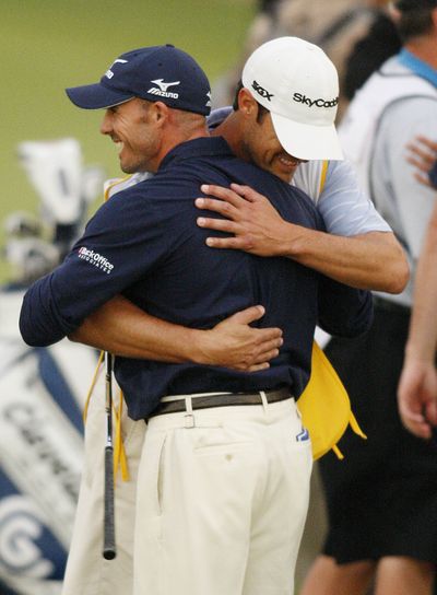 Jonathan Byrd hugs his caddie after hole-in-one. (Associated Press)