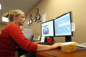 
Marissa Dodd looks at a chest X-ray and the accompanying patient file on her computer monitors at Nighthawk Radiology. The Coeur d'Alene representatives gather the electronic scans and organize the necessary information, then forward it to radiologists on standby around the world.
 (The Spokesman-Review)