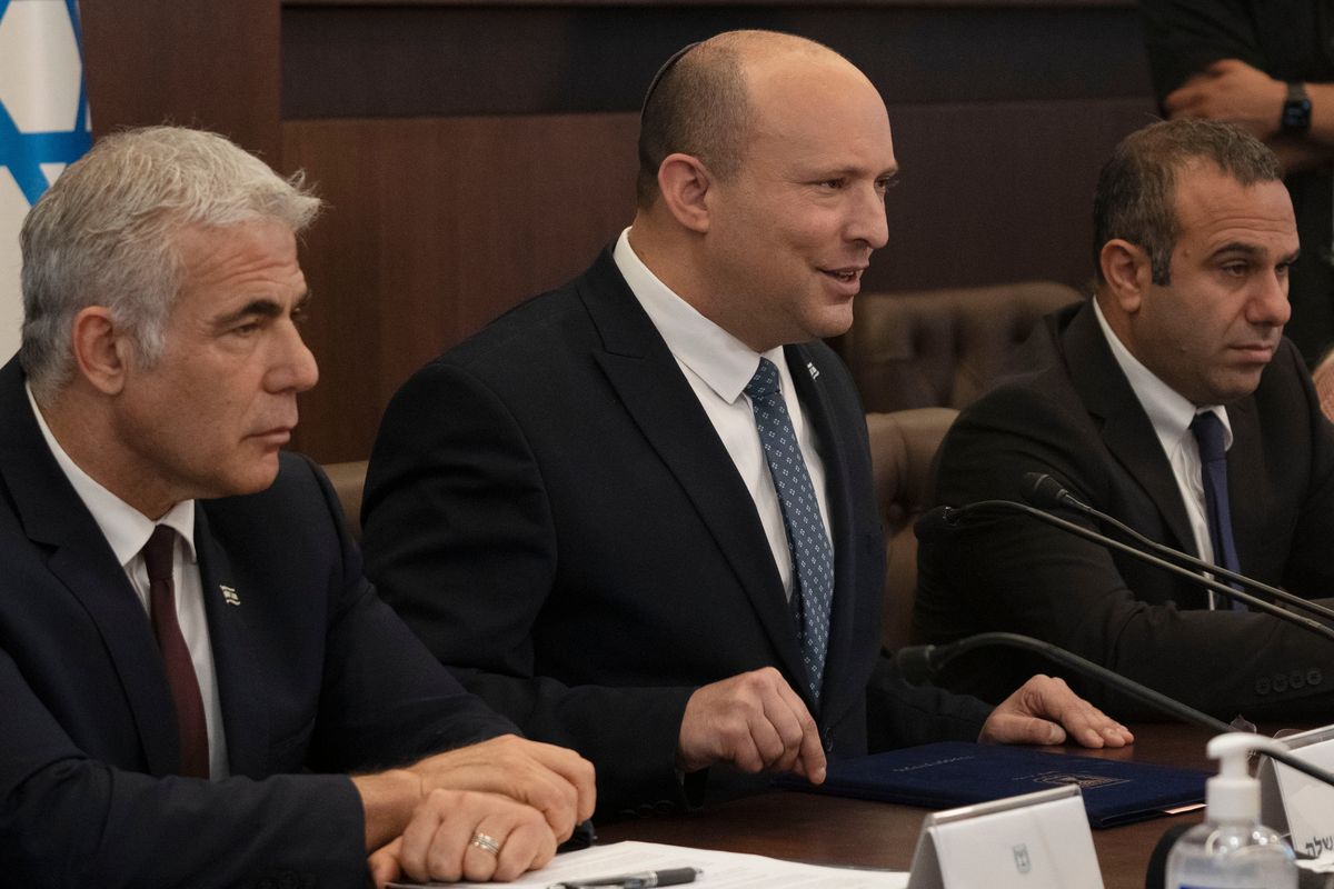 Israeli Prime Minister Naftali Bennett, center, makes a statement at the start of the weekly cabinet meeting seated next to Foreign Minister Yair Lapid, left, in Jerusalem, Sunday, May 8, 2022.  (Maya Alleruzzo)